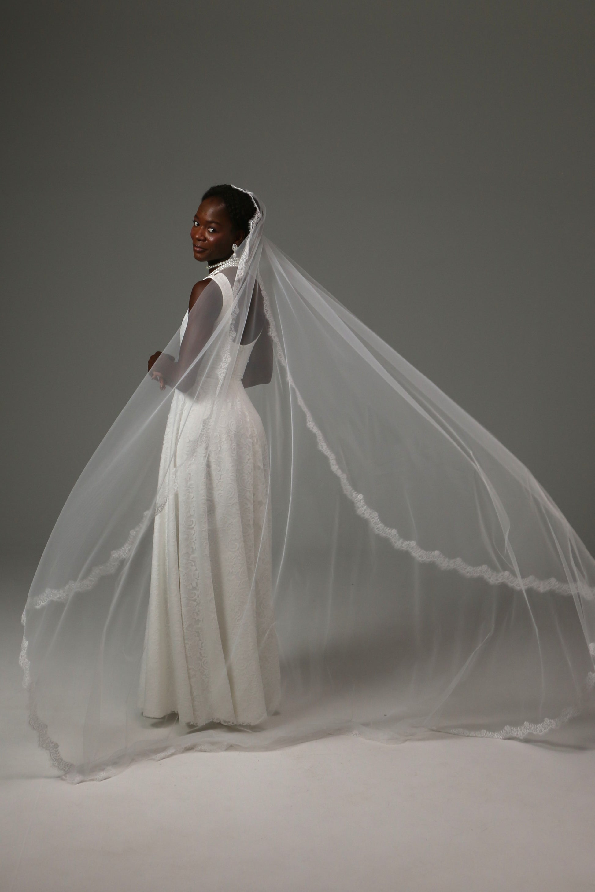 Elegant bridal veil draping naturally around a wedding gown.