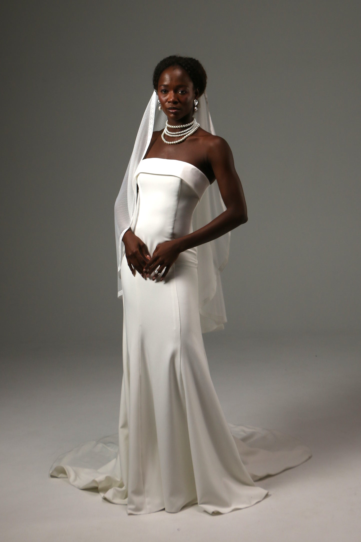 Bride wearing a soft dotted tulle veil with delicate lace trim.