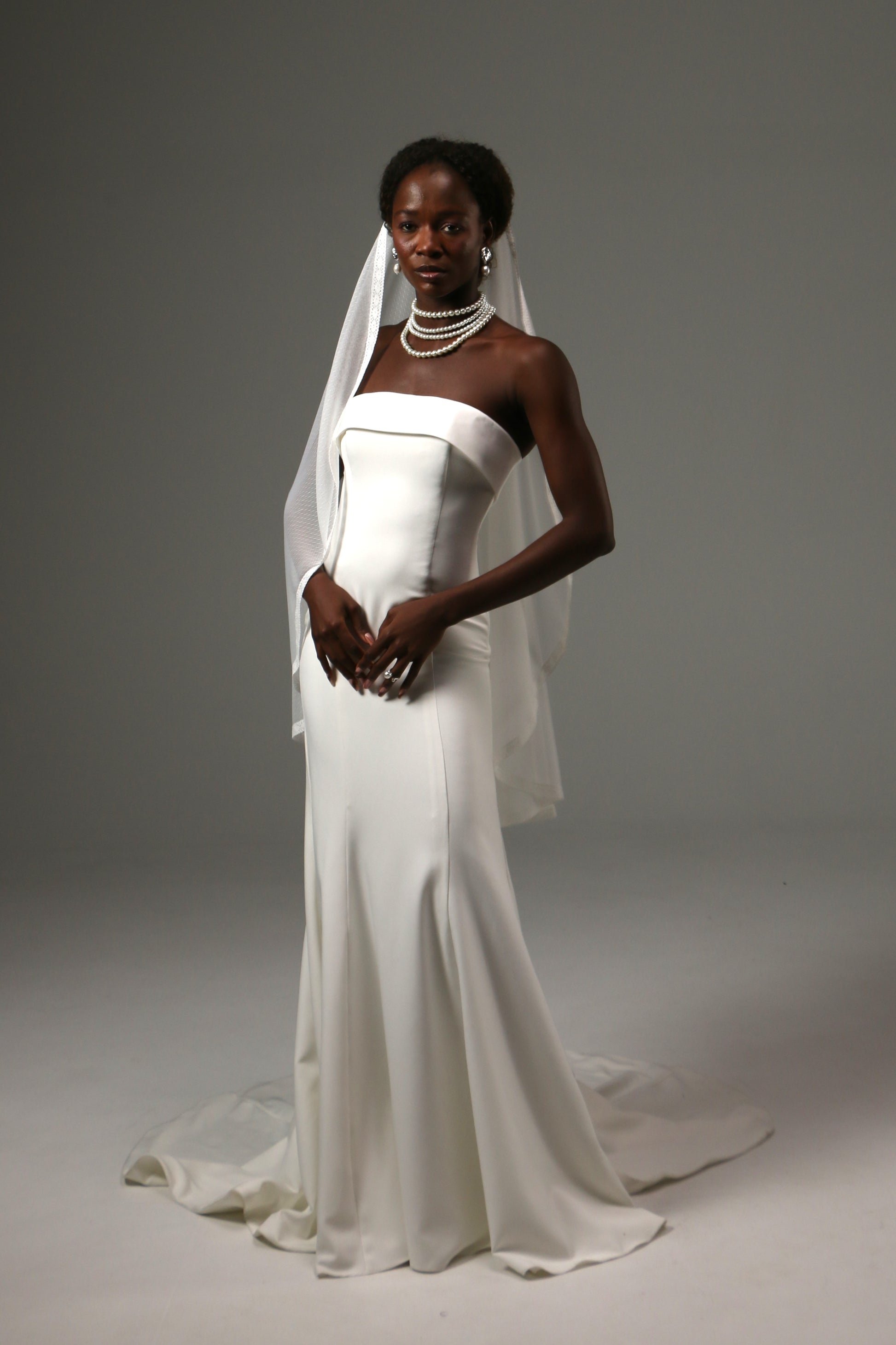 Bride wearing a soft dotted tulle veil with delicate lace trim.