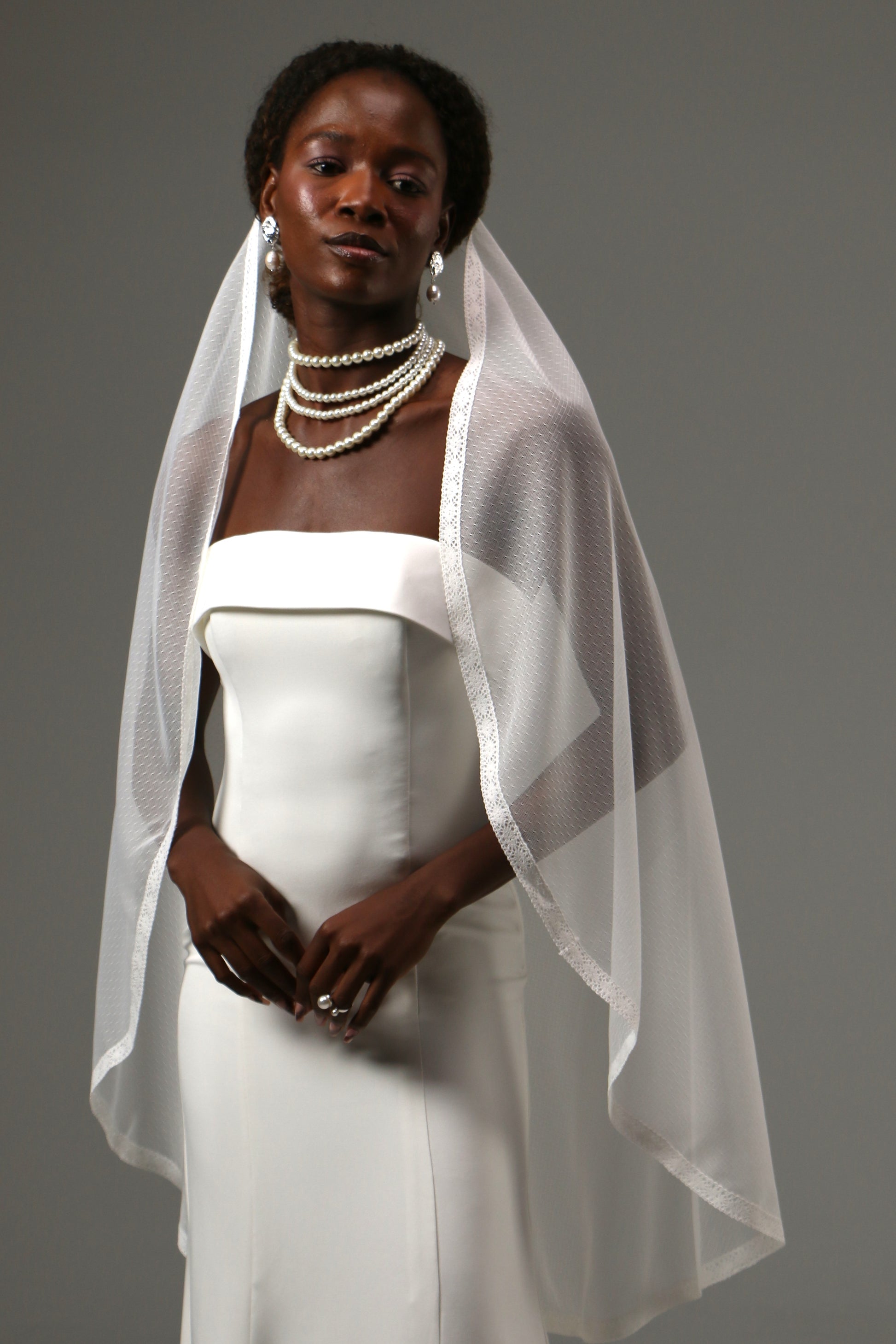 Soft tulle fingertip veil creating a light and airy bridal look.