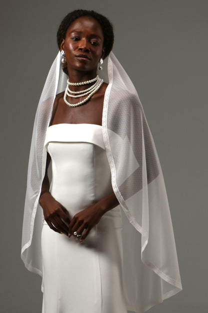 Soft tulle fingertip veil creating a light and airy bridal look.