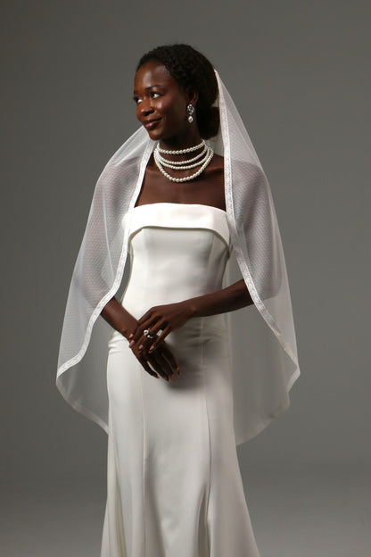 Fingertip bridal veil featuring romantic dotted texture and lace edging.