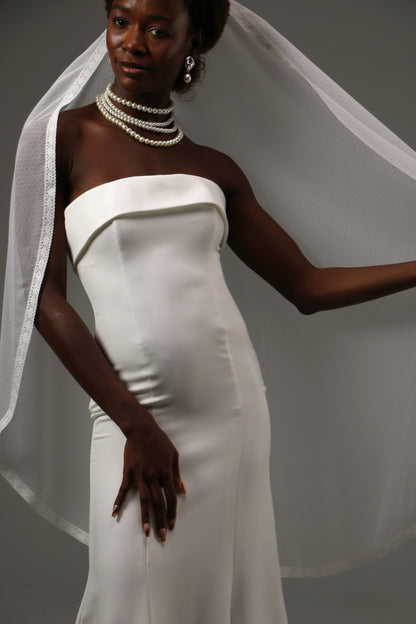 Delicate lace-edged veil with vintage-inspired dotted texture.