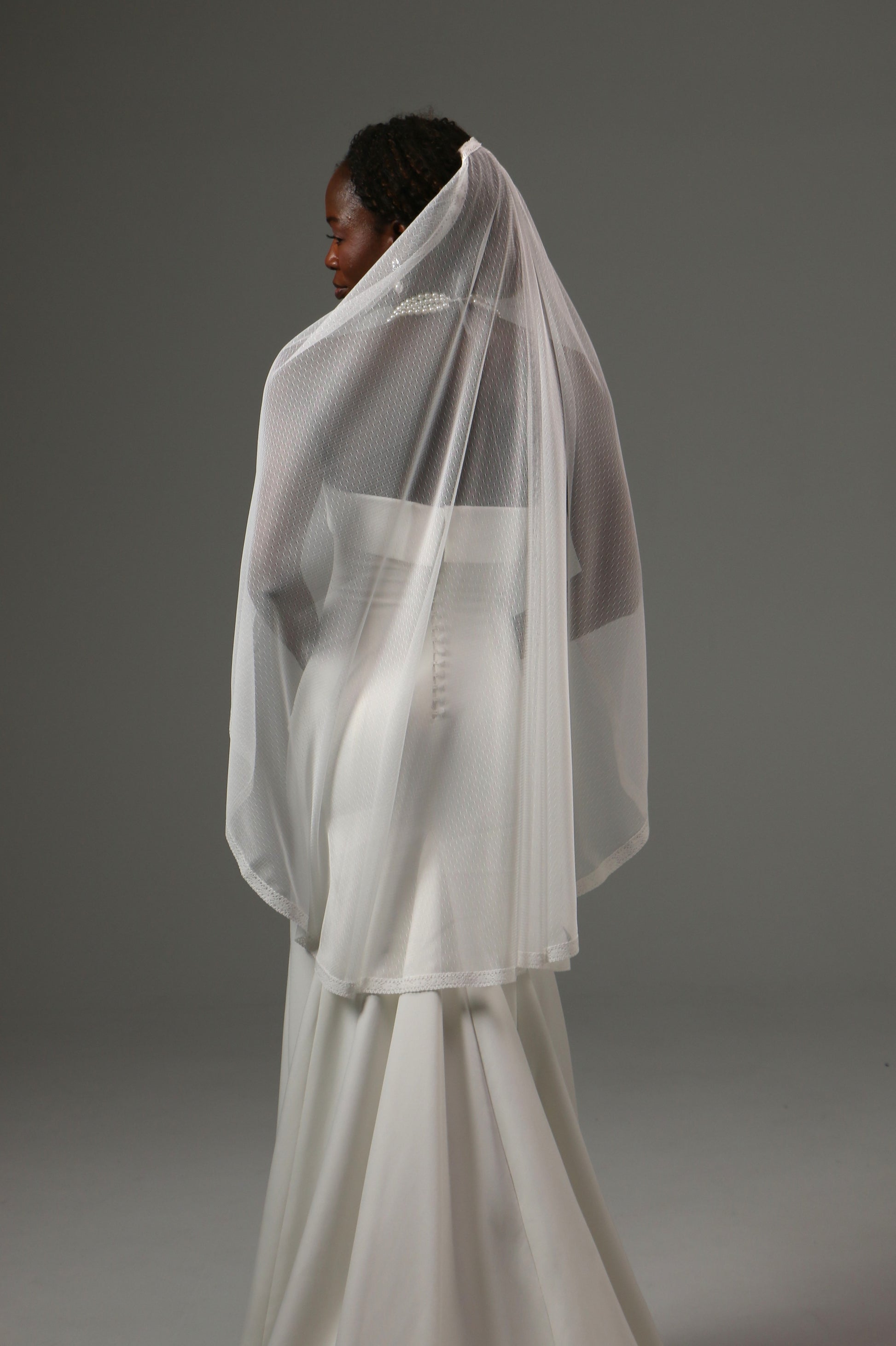 Elegant fingertip veil with fine lace border and flowing silhouette.