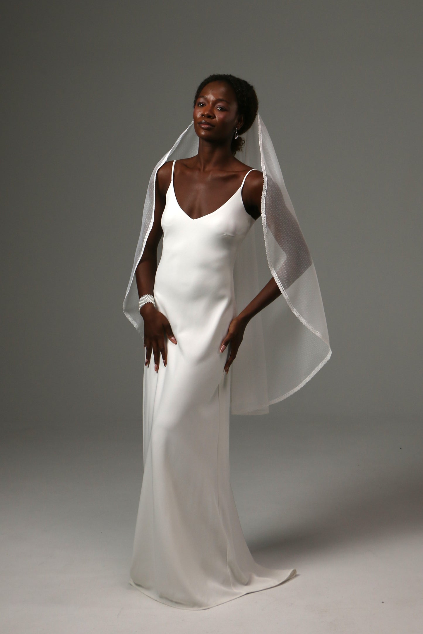Fingertip-length veil with delicate lace edging and soft drape.