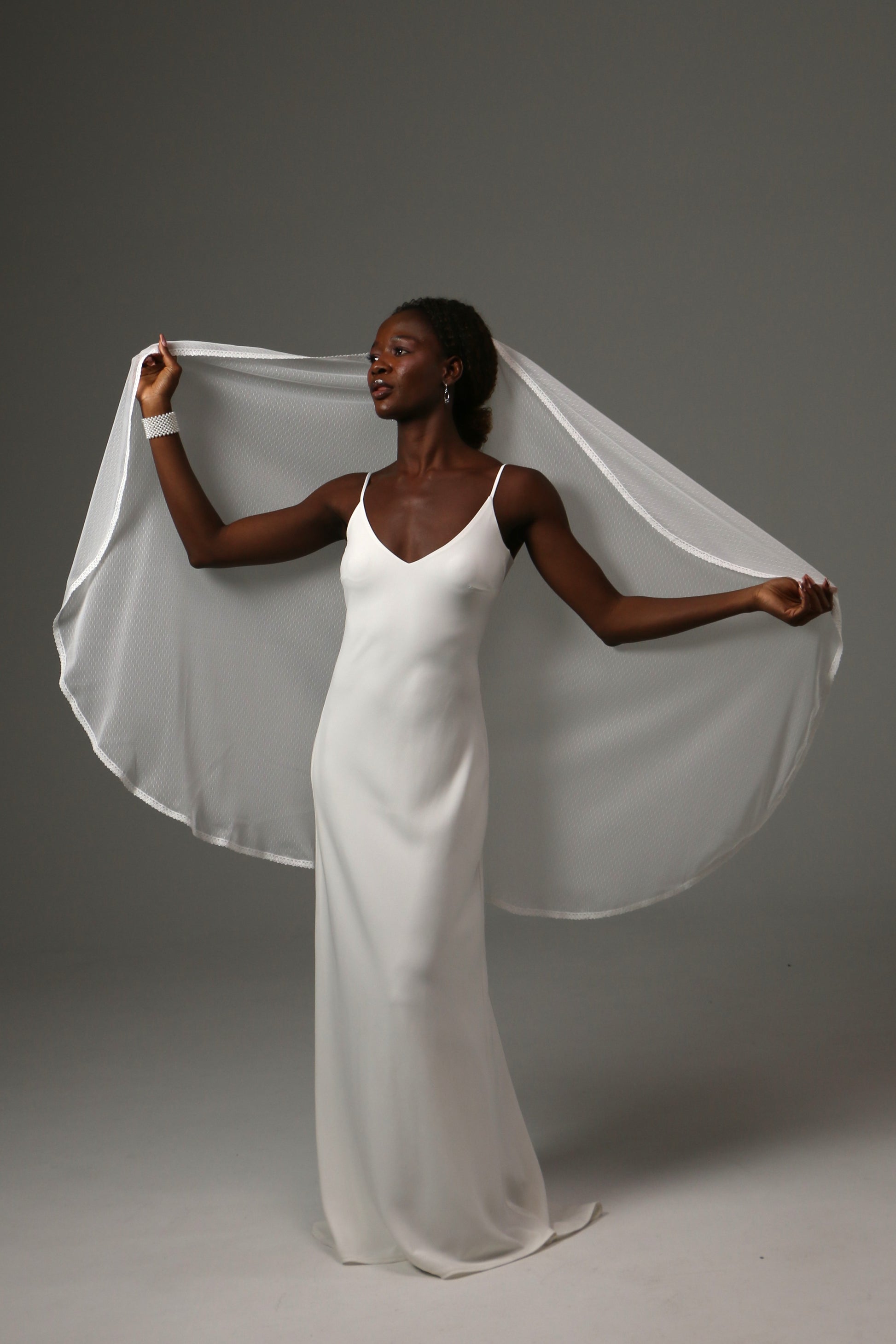 Romantic fingertip bridal veil featuring subtle dotted texture.