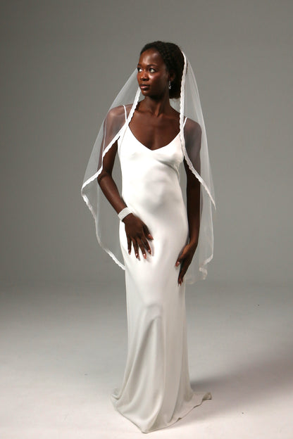 One-tier fingertip wedding veil with delicate lace edge trim.