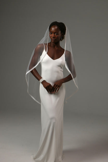Handmade wedding veil with soft drape and lace edge finish.