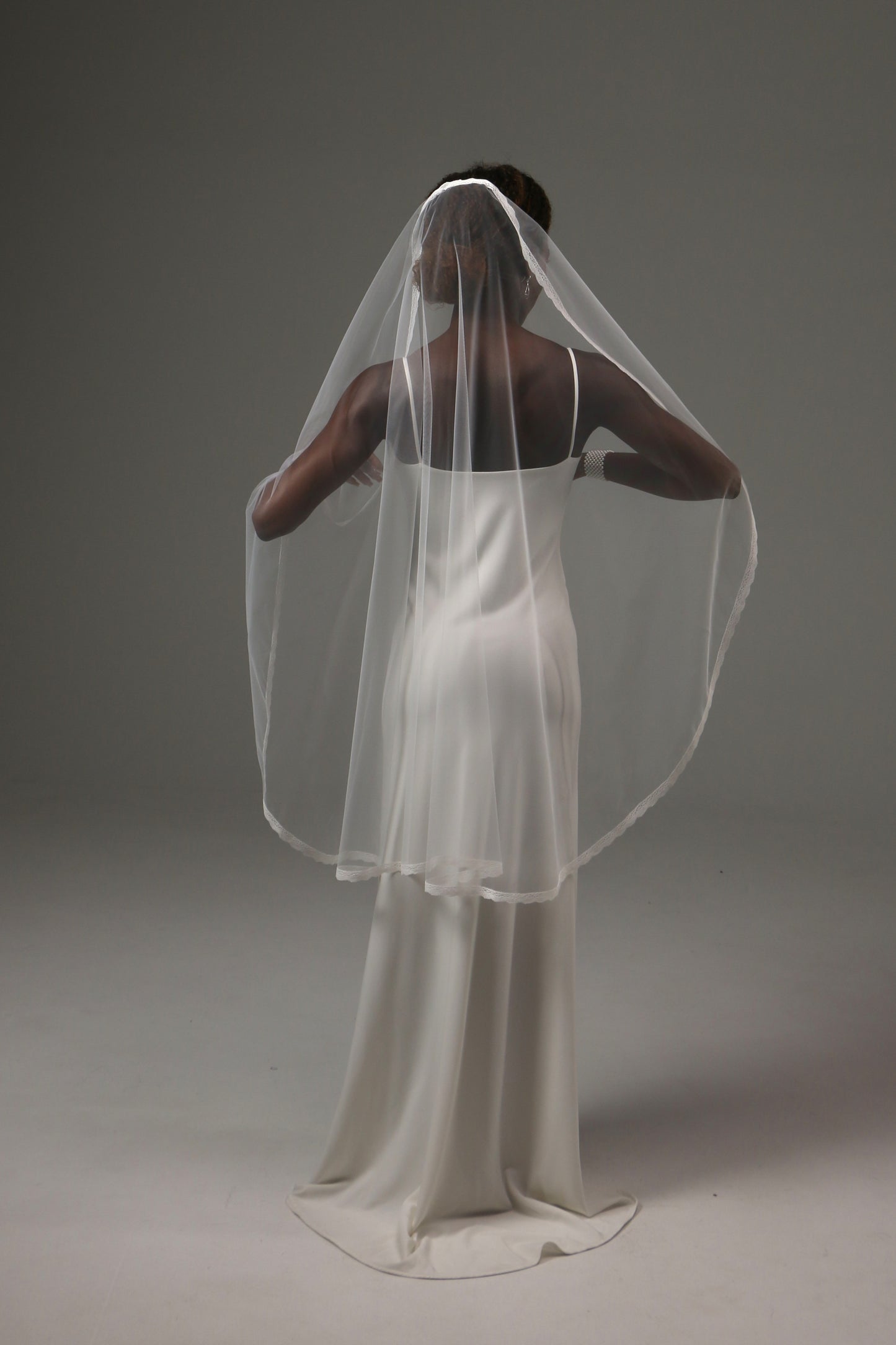 Minimalist wedding veil with delicate lace trim detail.