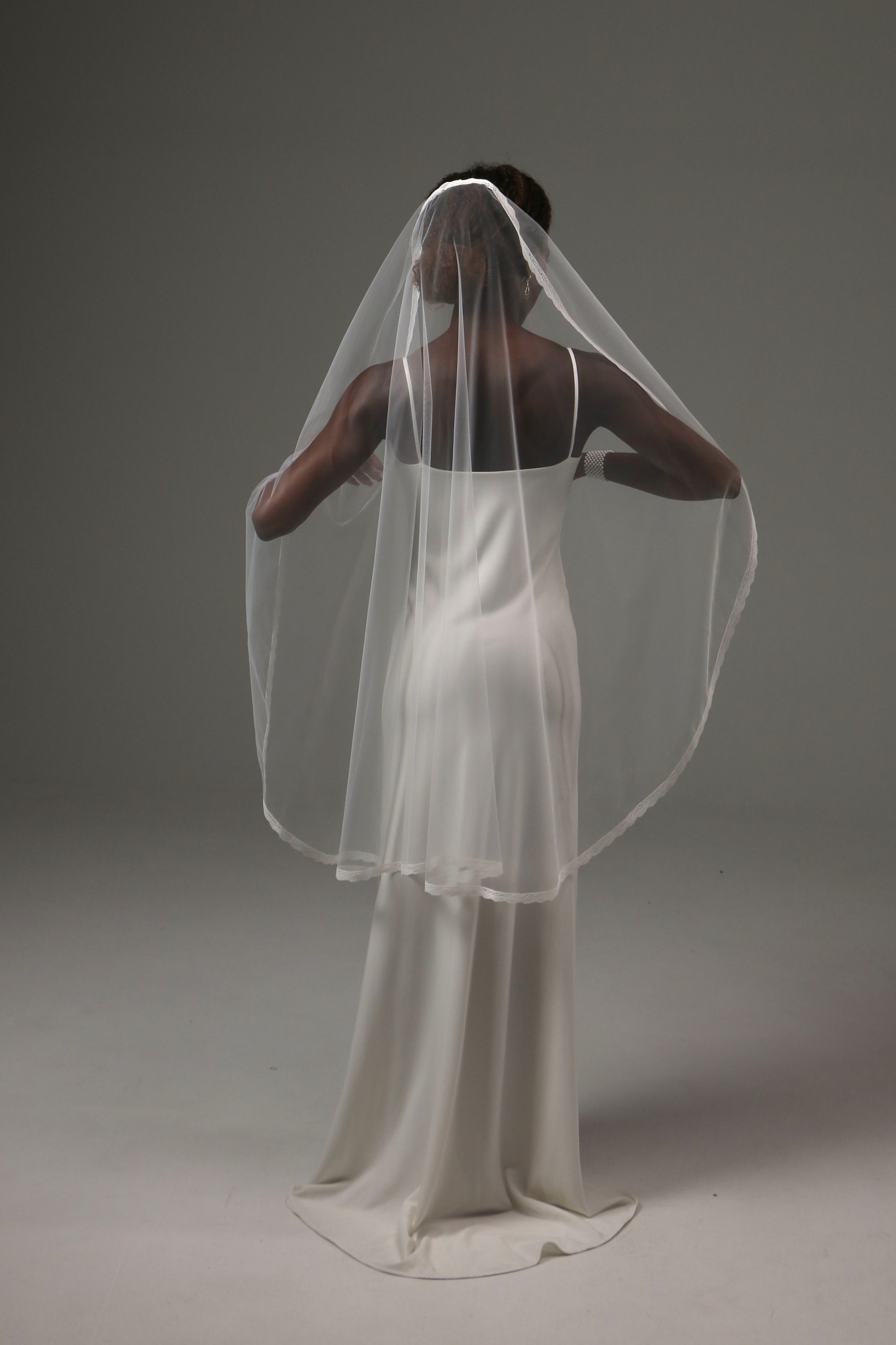 Minimalist wedding veil with delicate lace trim detail.