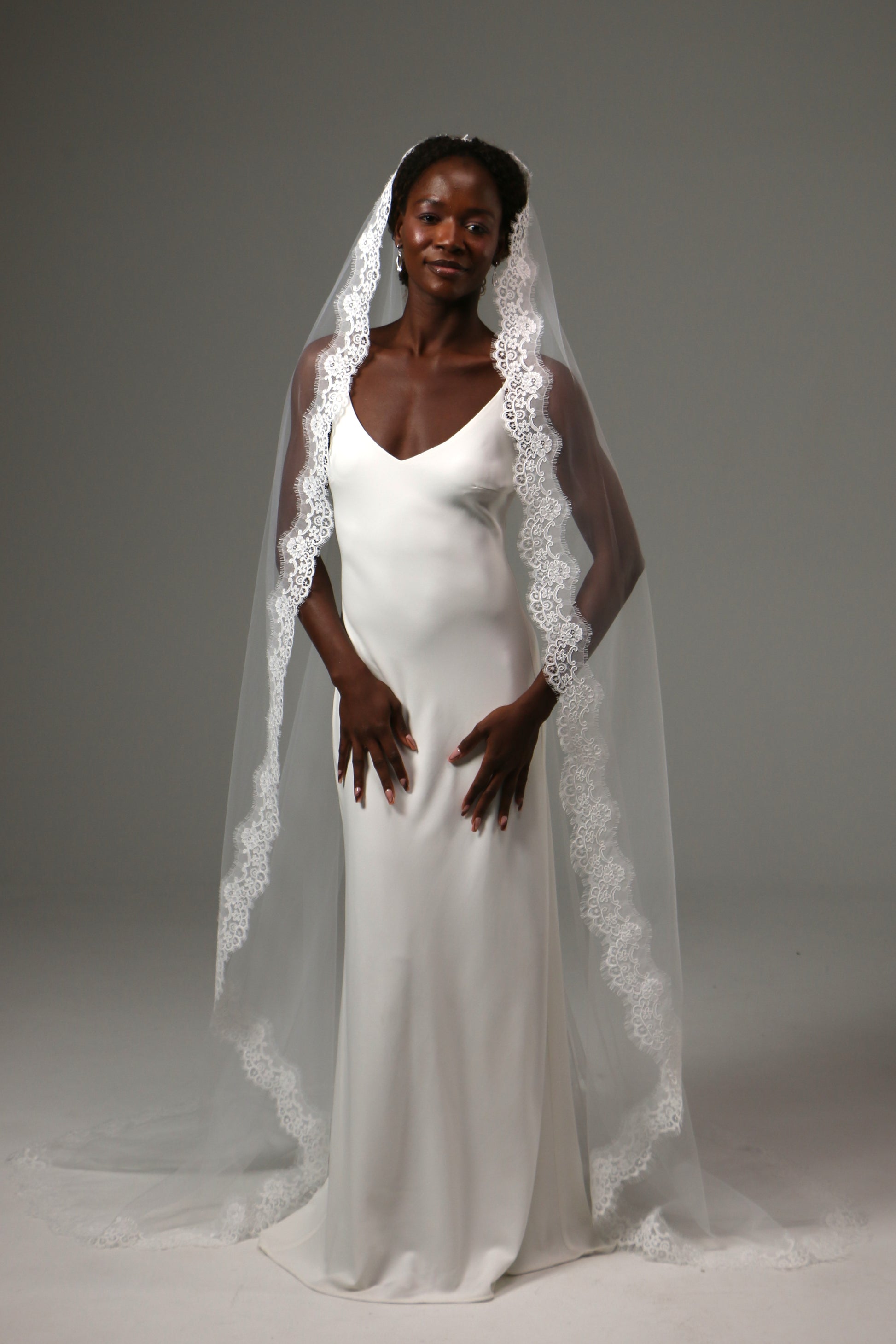 Bride wearing a cathedral-length veil with intricate lace detailing.