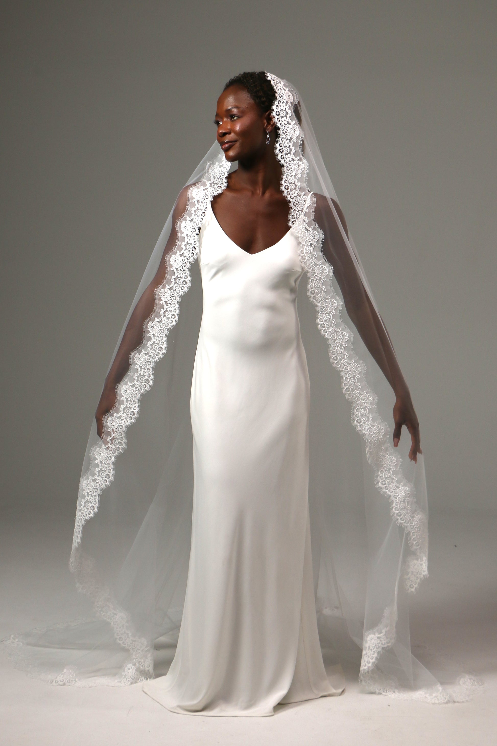 Traditional bridal veil with cathedral train and ornate lace border.
