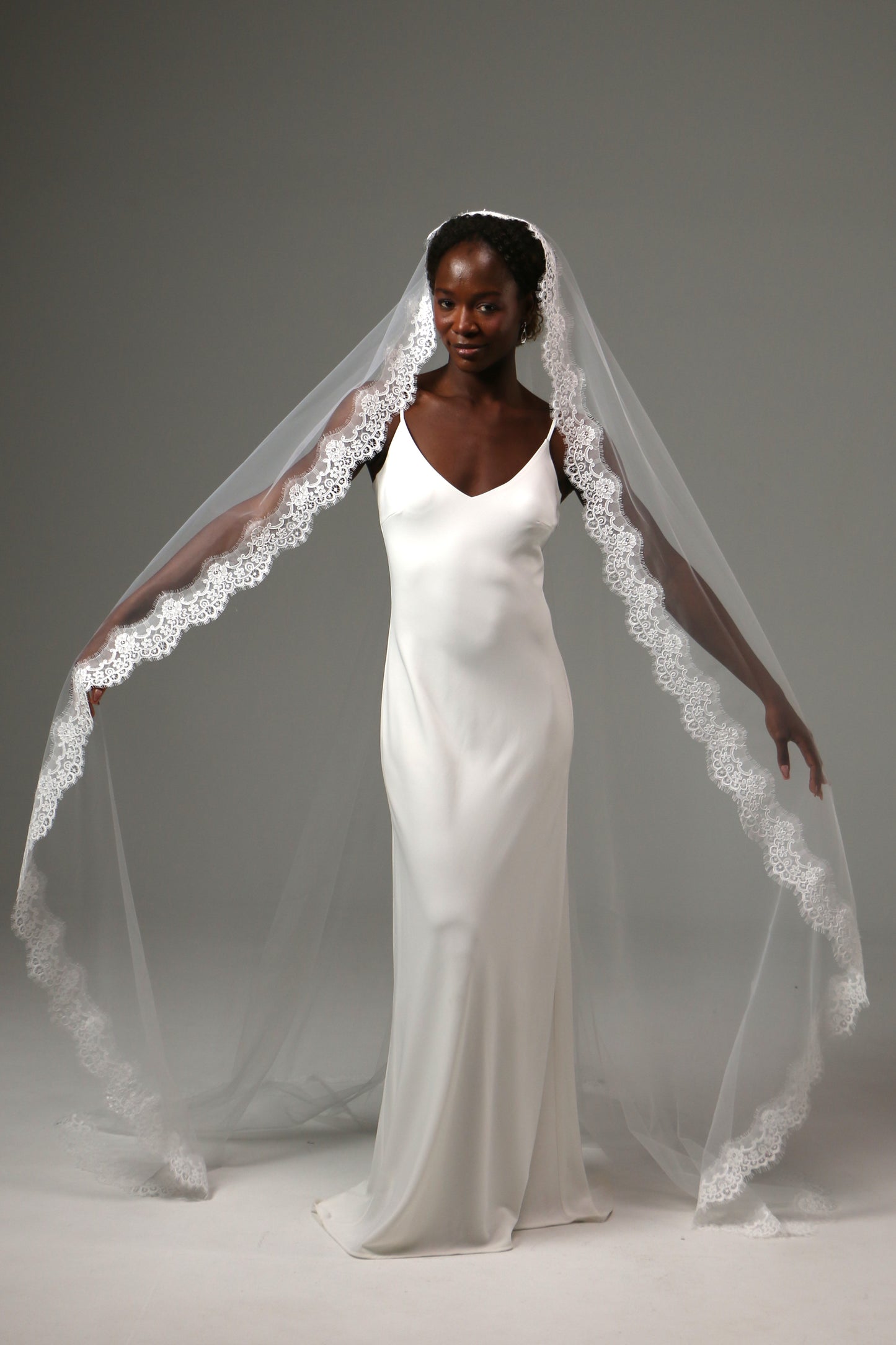 Cathedral-length bridal veil with delicate floral lace edging.