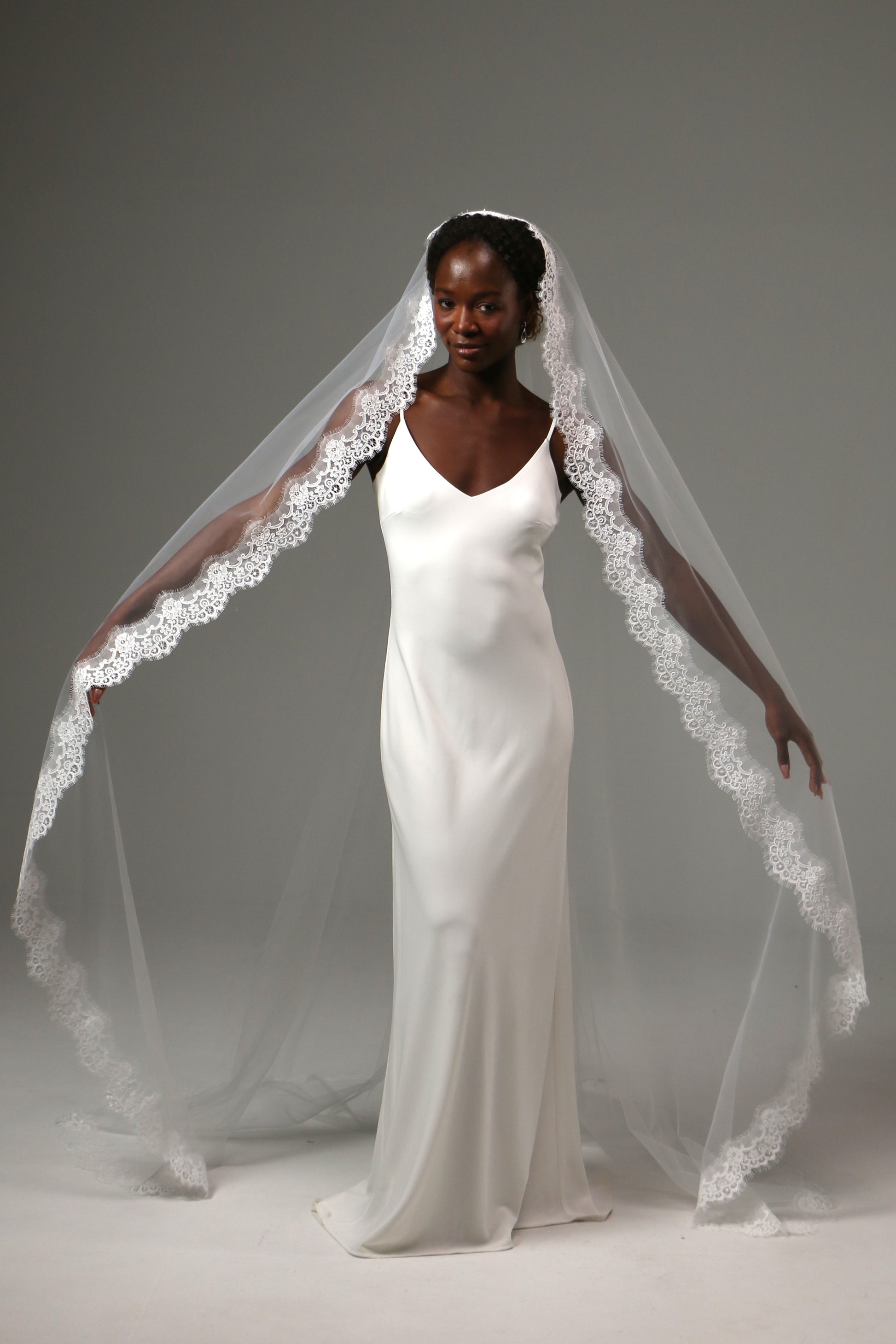 Cathedral-length bridal veil with delicate floral lace edging.