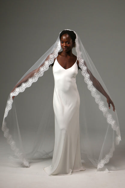 Cathedral-length bridal veil with delicate floral lace edging.