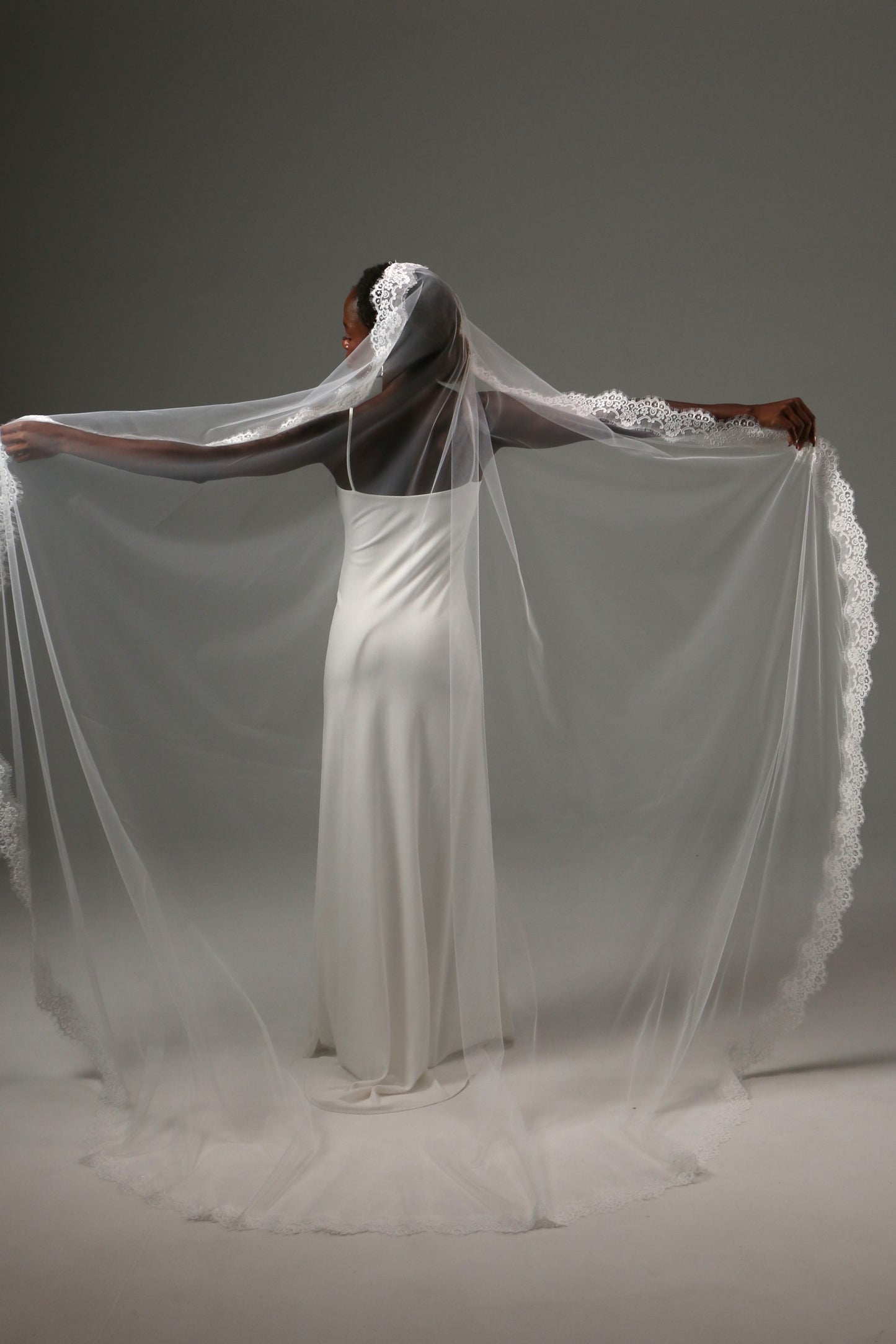 One-tier wedding veil with intricate lace trim and soft drape.