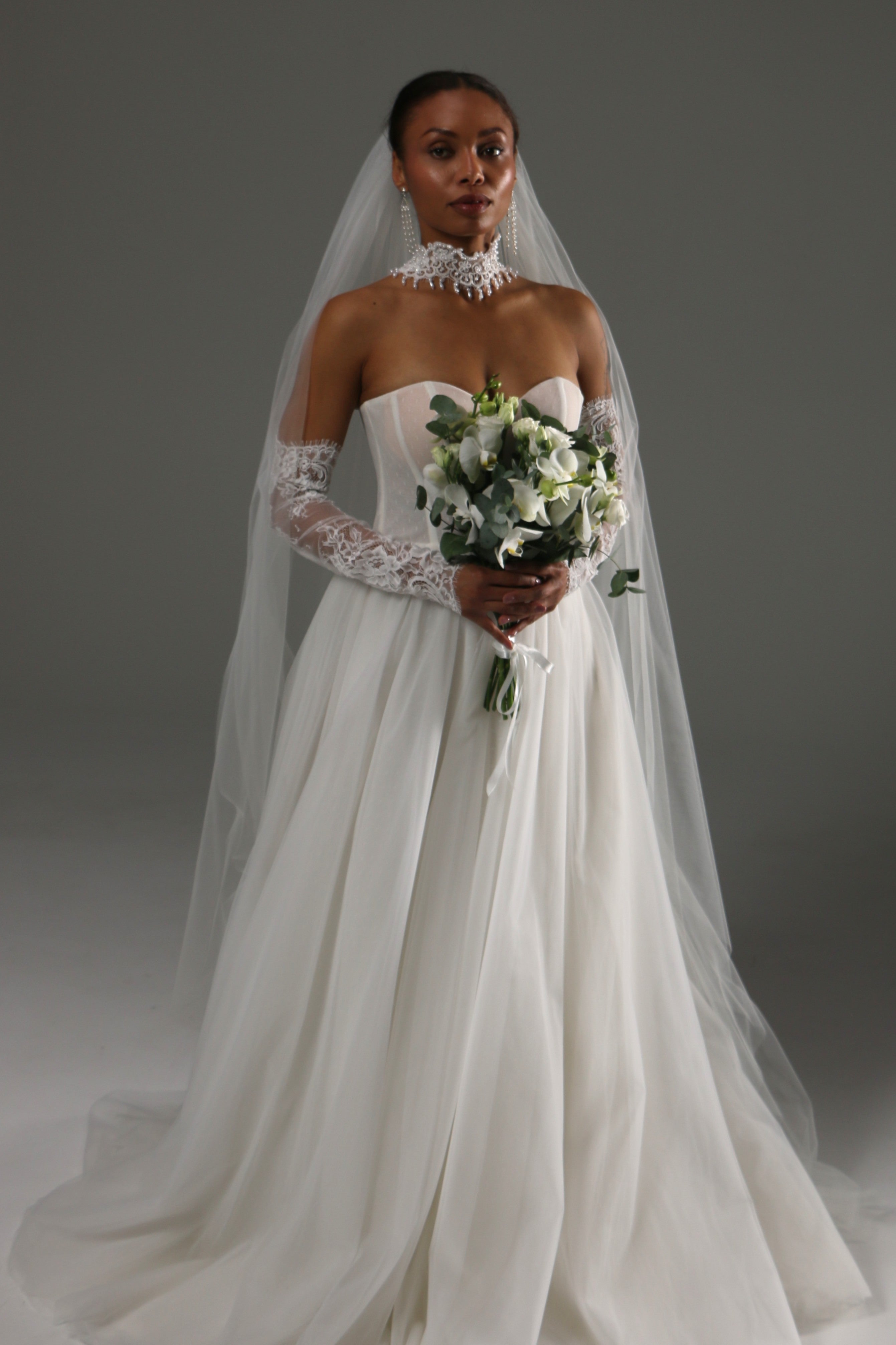 Bride wearing a raw edge wedding veil made of soft tulle in chapel length with a minimalist bridal gown.